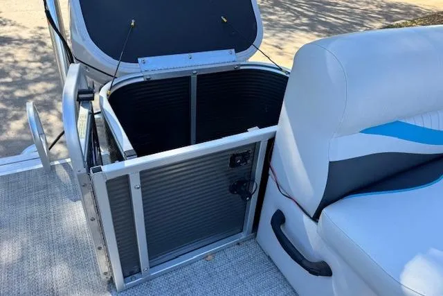 Slide: The Image of 2019 Qwest Edge 280 Cruise boat interior with open storage compartment and cushioned seating. - 17