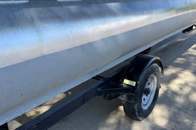 Slide: The Image of 2019 Qwest Edge 280 Cruise boat on trailer, side view, showing metal hull and wheel. - 21