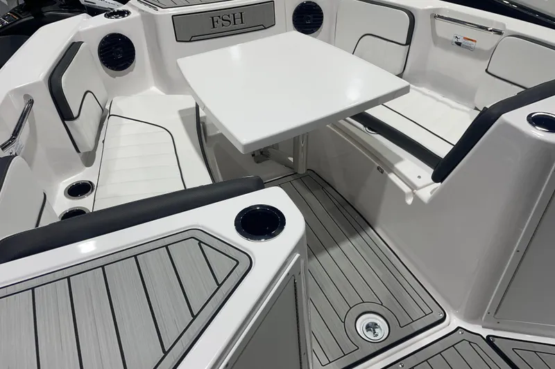Slide: The Image of 2025 Yamaha Boats 222 FSH Sport E interior with seating and table, featuring sleek design. - 5