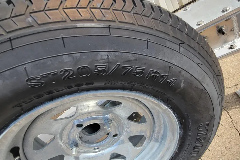 Slide: The Image of Close-up of a tire on a 2025 AQUAWKA BOATS 2072 ALUMINUM trailer. - 16
