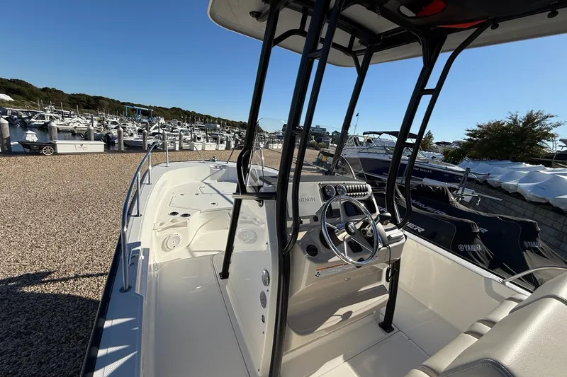 Slide: The Image of 2023 Boston Whaler 210 Montauk boat interior with steering console, docked at marina. - 15