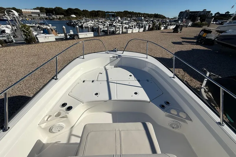Slide: The Image of 2023 Boston Whaler 210 Montauk boat interior at marina, showcasing spacious deck and seating. - 19