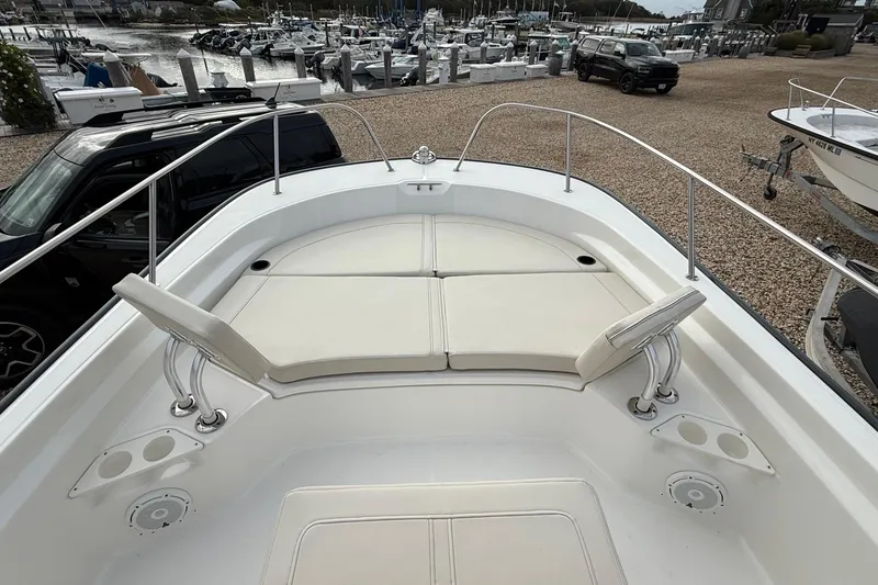 Slide: The Image of 2023 Boston Whaler 210 Montauk boat interior with cushioned seating and cup holders. - 21
