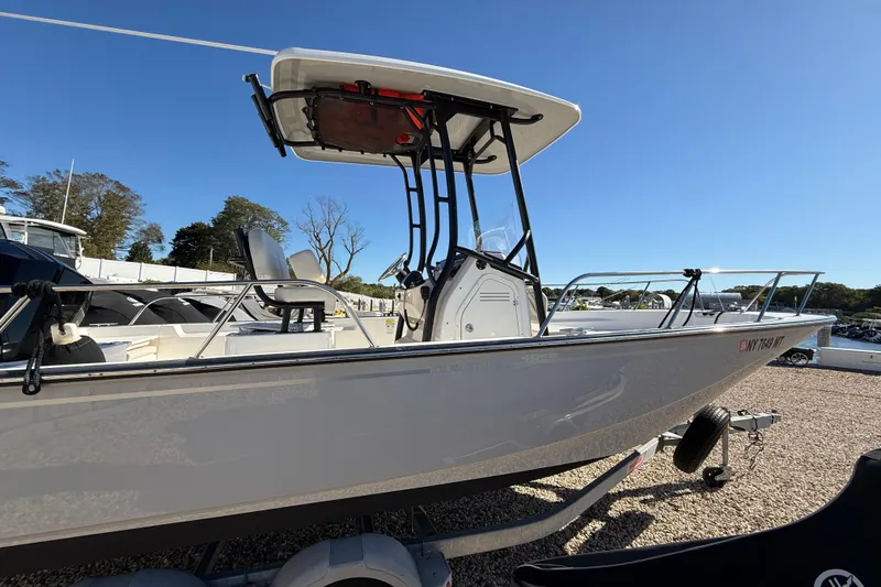 Slide: The Image of 2023 Boston Whaler 210 Montauk boat on trailer under clear blue sky. - 24
