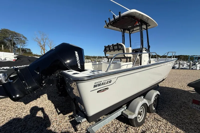 Slide: The Image of 2023 Boston Whaler 210 Montauk boat with Mercury engine on trailer, outdoor setting. - 4