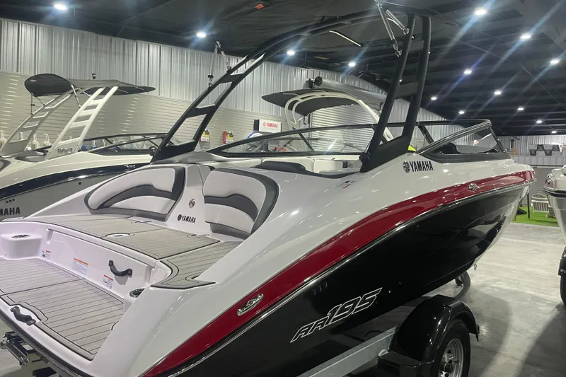 Slide: The Image of 2025 Yamaha Boats AR195 in showroom, sleek design with red and black accents. - 2