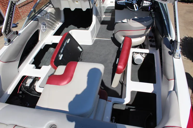 Slide: The Image of 2011 MasterCraft X-15 interior with red and white seating, open storage compartments, and steering wheel. - 12