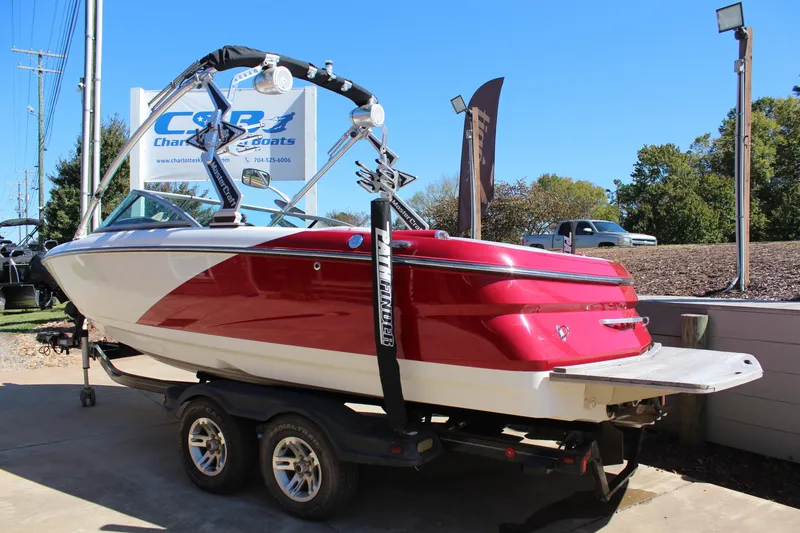 Slide: The Image of 2011 MasterCraft X-15 boat on trailer, red and white design, outdoor display. - 4