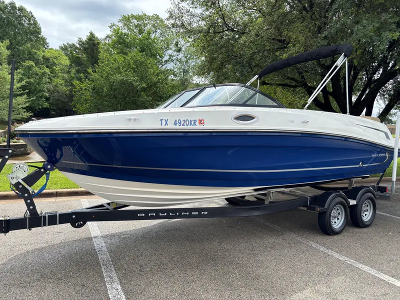 The Image of 2022 Bayliner VR6 Bowrider I/O on trailer, parked outdoors, blue and white design. - 0