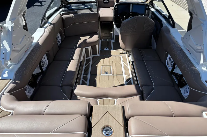 Slide: The Image of 2026 Centurion Ri230 boat interior with tan seating and integrated speaker system. - 11