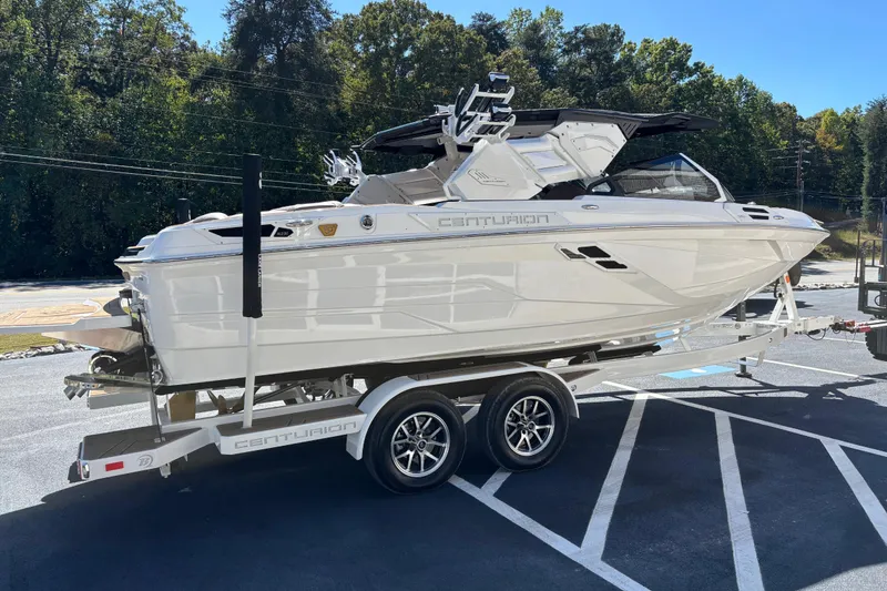 Slide: The Image of 2026 Centurion Ri230 boat on trailer, parked outdoors in a sunny setting. - 5