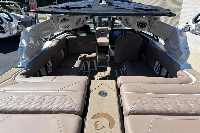 Slide: The Image of 2026 Centurion Ri230 boat rear view with swim platform and speakers, parked outdoors. - 7