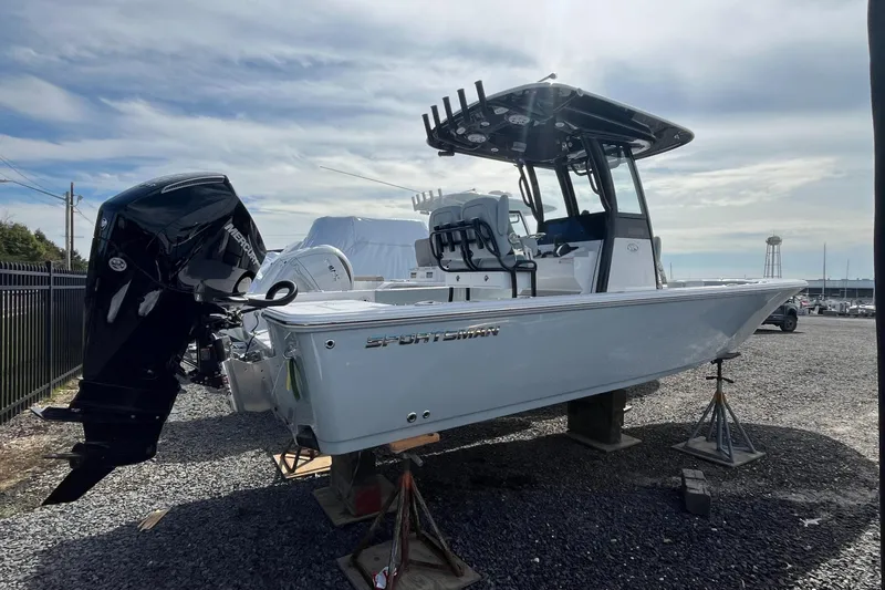 The Image of 2026 Sportsman Masters 247OE Bay Boat on display, featuring a powerful outboard motor. - 0