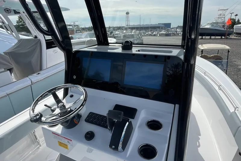 Slide: The Image of 2026 Sportsman Masters 247OE Bay Boat dashboard with dual screens and steering wheel. - 2