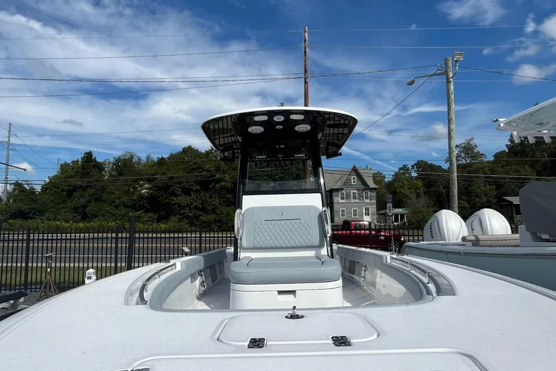 Slide: The Image of 2026 Sportsman Masters 247OE Bay Boat with T-top, parked outdoors under blue sky. - 8