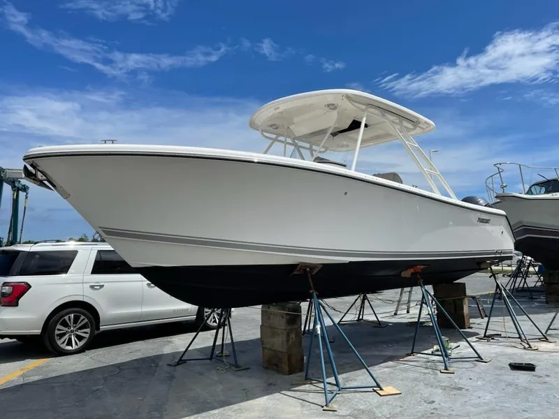 The Image of 2015 Pursuit S 280 Sport boat on stands under clear blue sky. - 0