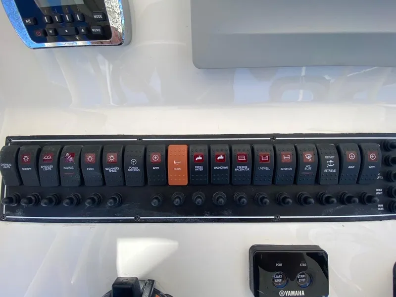 Slide: The Image of Control panel of a 2015 Pursuit S 280 Sport boat with various switches and Yamaha display. - 10