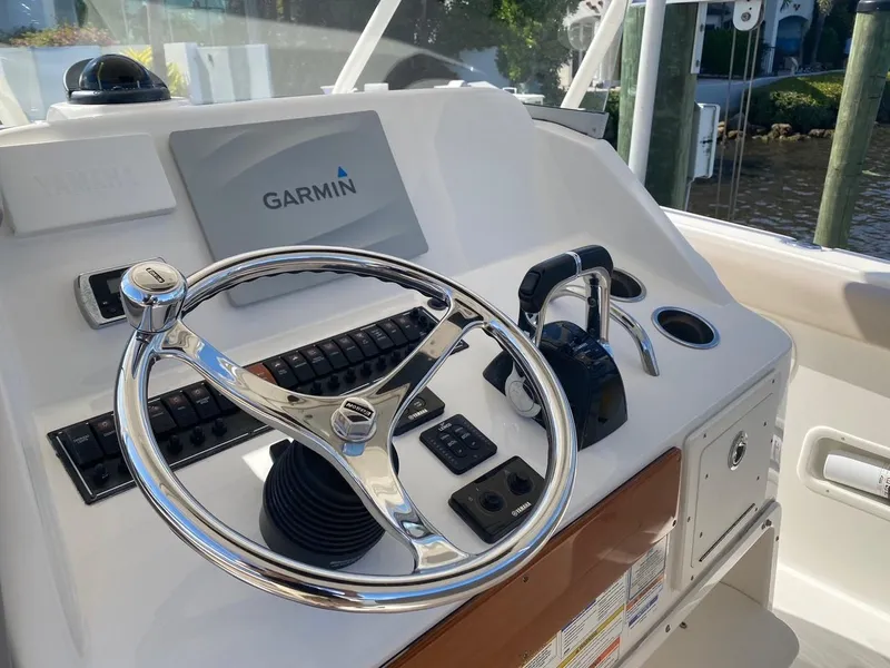 Slide: The Image of 2015 Pursuit S 280 Sport boat helm with Garmin navigation system and chrome steering wheel. - 11