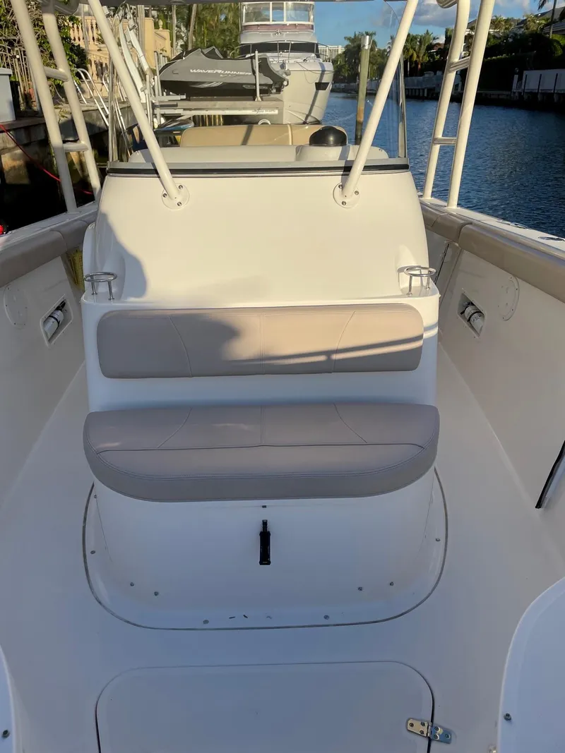 Slide: The Image of 2015 Pursuit S 280 Sport boat interior with seating, docked by a canal. - 12