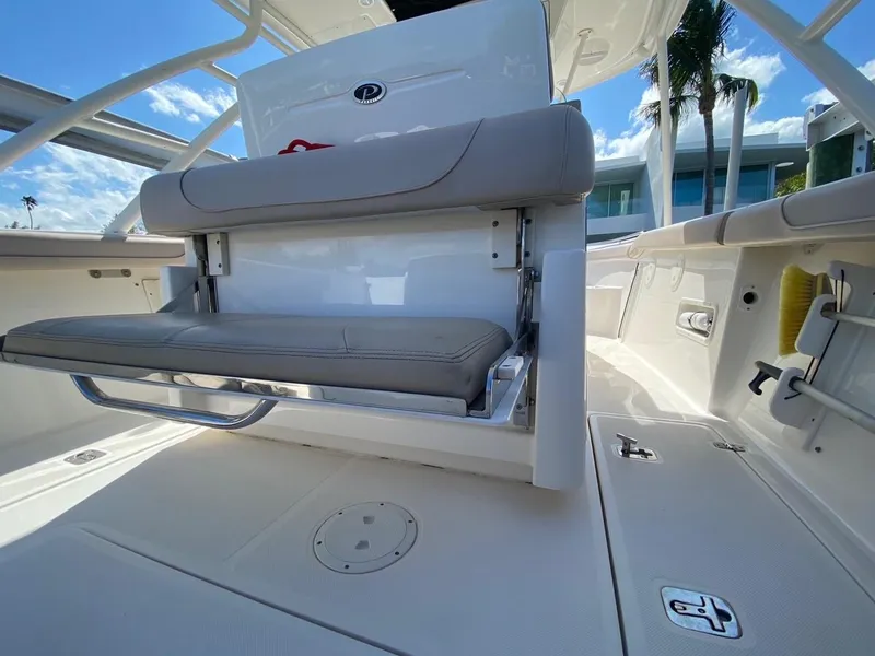 Slide: The Image of 2015 Pursuit S 280 Sport boat interior with seating and storage, under clear blue sky. - 18