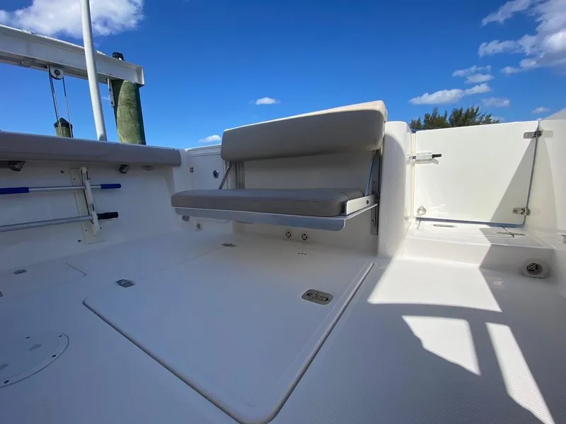Slide: The Image of 2015 Pursuit S 280 Sport boat interior with foldable seating under a clear blue sky. - 21