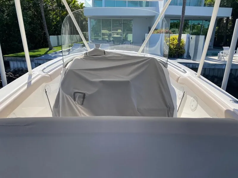 Slide: The Image of 2015 Pursuit S 280 Sport boat with covered console, docked near modern waterfront home. - 26