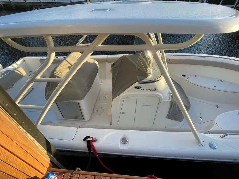 Slide: The Image of 2015 Pursuit S 280 Sport boat docked, featuring covered seating and sleek design. - 5