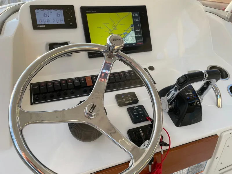 Slide: The Image of Control panel of a 2015 Pursuit S 280 Sport boat with steering wheel and navigation screens. - 7