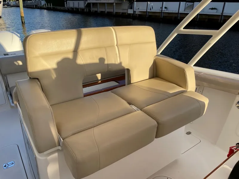 Slide: The Image of 2015 Pursuit S 280 Sport boat with beige leather seating by the water. - 8