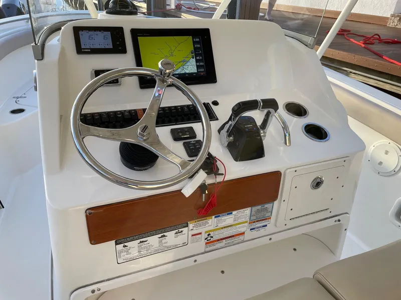 Slide: The Image of Control panel of a 2015 Pursuit S 280 Sport boat with steering wheel and navigation display. - 9