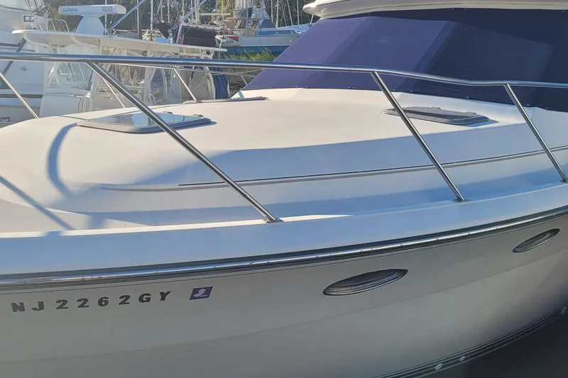 Slide: The Image of 1988 Tiara Yachts 3600 Convertible boat docked, showcasing sleek design and railings. - 11