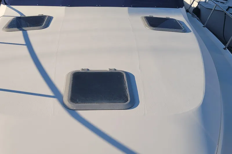 Slide: The Image of 1988 Tiara Yachts 3600 Convertible deck with three hatches, sunlight casting shadows. - 13