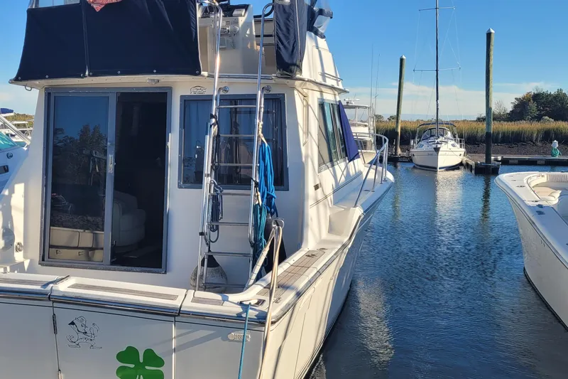 Slide: The Image of 1988 Tiara Yachts 3600 Convertible docked in a marina, featuring a sleek design and spacious deck. - 3
