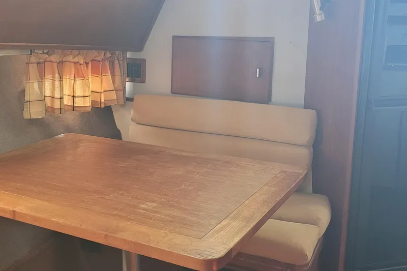 Slide: The Image of Interior of 1988 Tiara Yachts 3600 Convertible with wooden table and beige seating. - 42