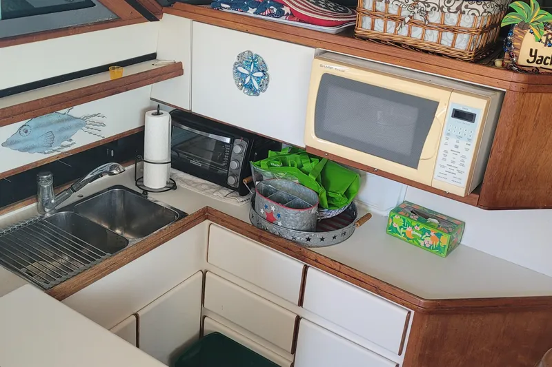 Slide: The Image of 1988 Tiara Yachts 3600 Convertible kitchen with sink, microwave, and storage. - 43