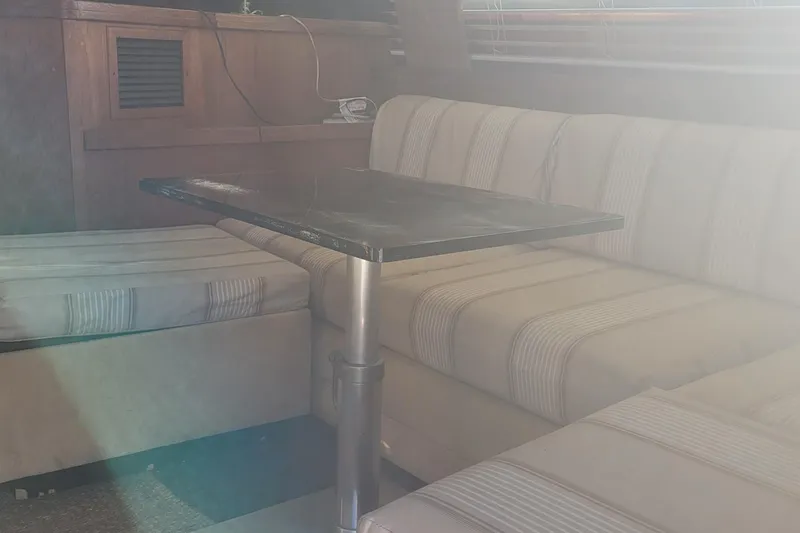 Slide: The Image of Interior of 1988 Tiara Yachts 3600 Convertible with striped seating and table. - 47