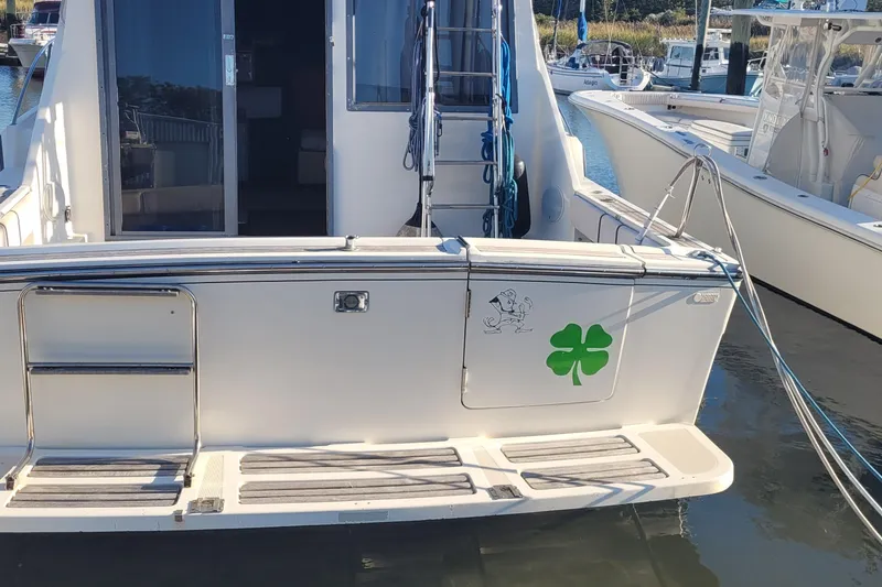 Slide: The Image of 1988 Tiara Yachts 3600 Convertible with green shamrock decal at marina. - 5