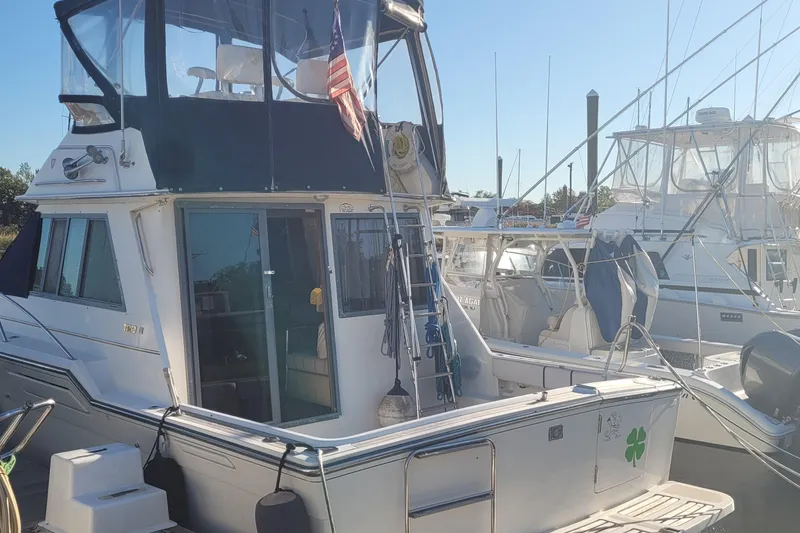 Slide: The Image of 1988 Tiara Yachts 3600 Convertible docked at marina, featuring flybridge and American flag. - 6