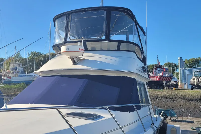 Slide: The Image of 1988 Tiara Yachts 3600 Convertible docked, featuring a sleek design and spacious flybridge. - 9