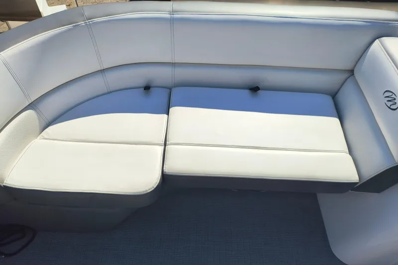 Slide: The Image of 2022 Manitou Aurora VP 23 boat interior with white cushioned seating. - 12