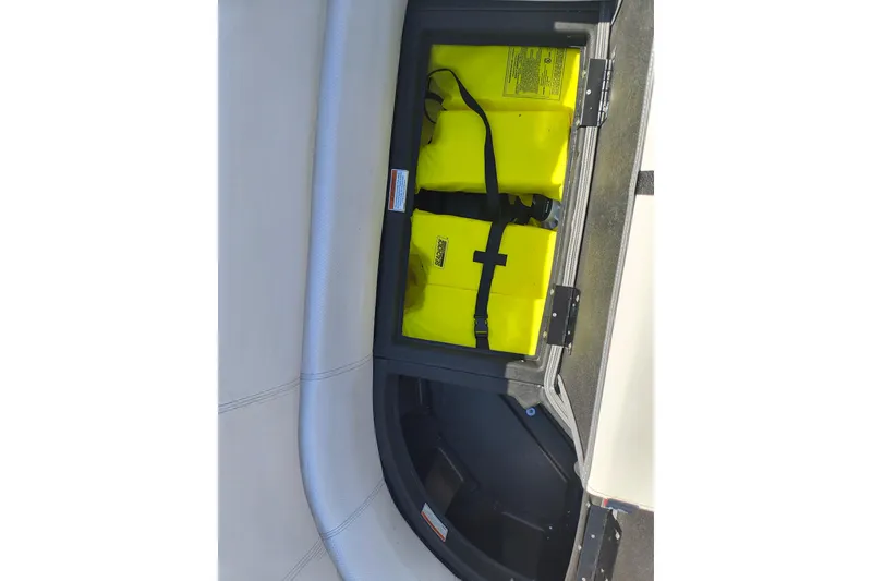 Slide: The Image of Storage compartment with yellow life jackets on a 2022 Manitou Aurora VP 23 boat. - 13