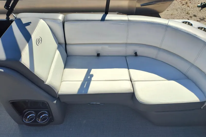 Slide: The Image of 2022 Manitou Aurora VP 23 boat seating with white upholstery and cup holders. - 20