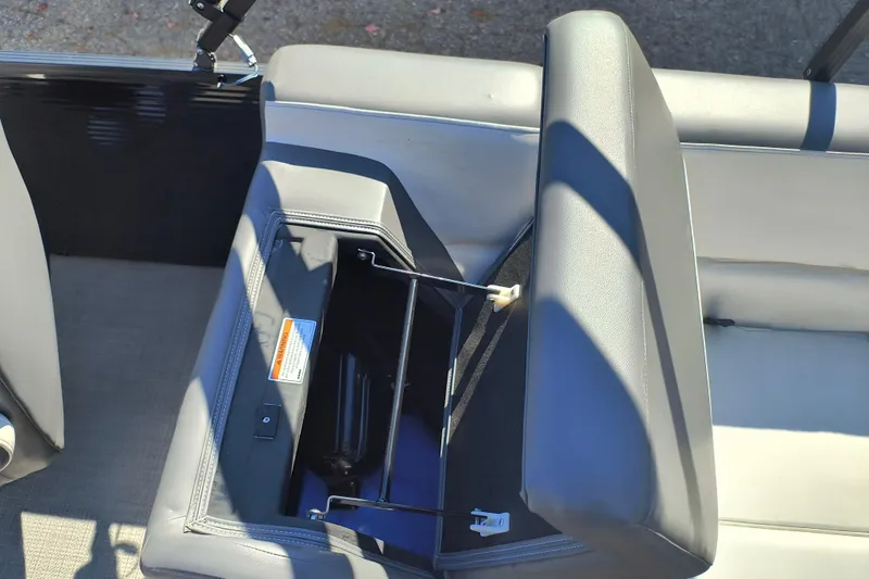 Slide: The Image of 2022 Manitou Aurora VP 23 boat seat storage compartment open, showcasing interior details. - 21