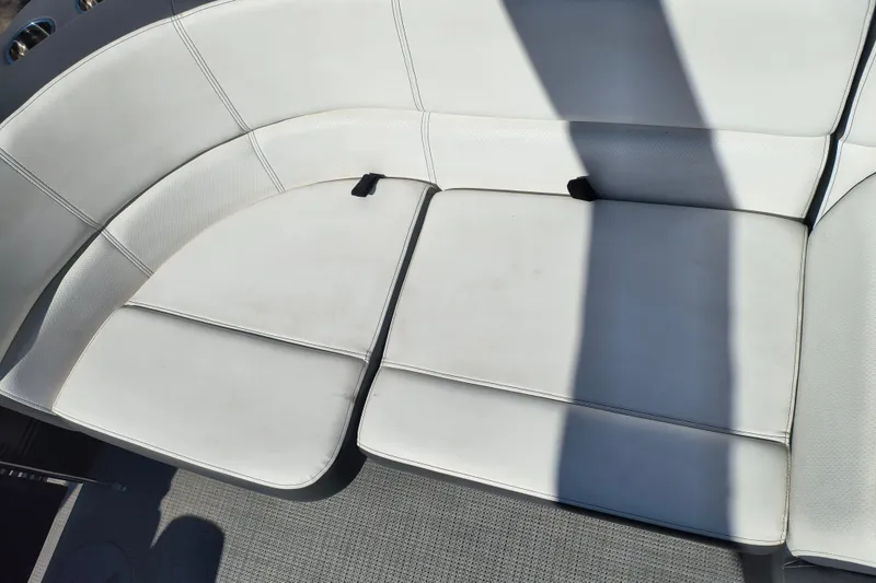 Slide: The Image of 2022 Manitou Aurora VP 23 boat seating with white upholstery and shadow. - 23
