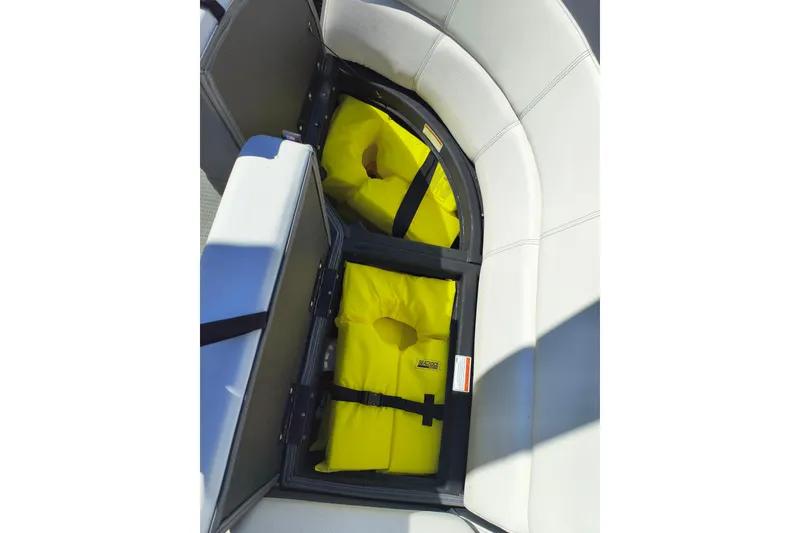 Slide: The Image of 2022 Manitou Aurora VP 23 boat seat storage with yellow life jackets. - 24