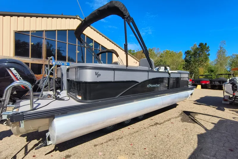 Slide: The Image of 2022 Manitou Aurora VP 23 pontoon boat parked outdoors on a sunny day. - 25
