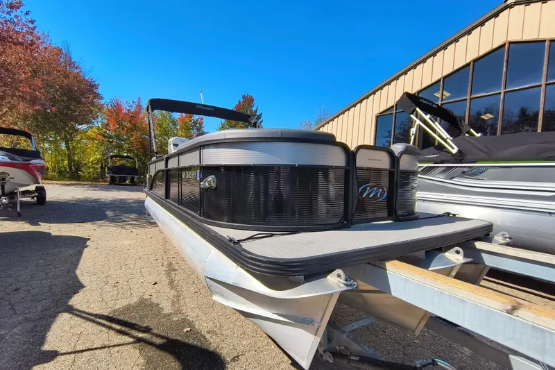 Slide: The Image of 2022 Manitou Aurora VP 23 pontoon boat parked outdoors on a sunny day. - 26