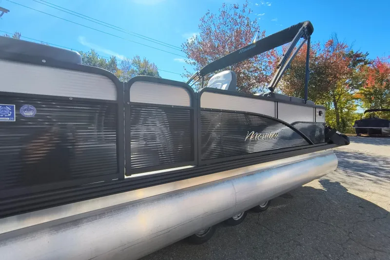 Slide: The Image of 2022 Manitou Aurora VP 23 pontoon boat under clear blue sky with autumn trees. - 27