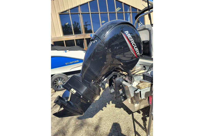 Slide: The Image of Mercury outboard motor on 2022 Manitou Aurora VP 23 boat, parked outdoors. - 29