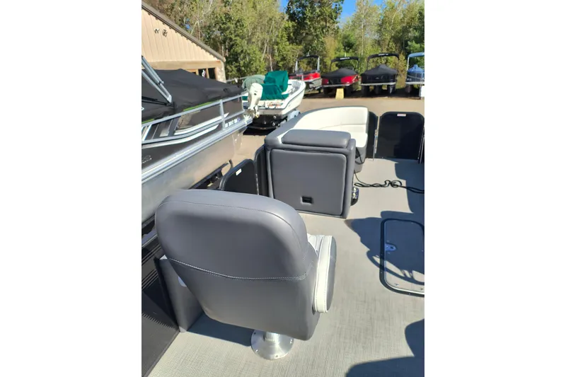 Slide: The Image of 2022 Manitou Aurora VP 23 boat interior with gray seating and outdoor setting. - 4